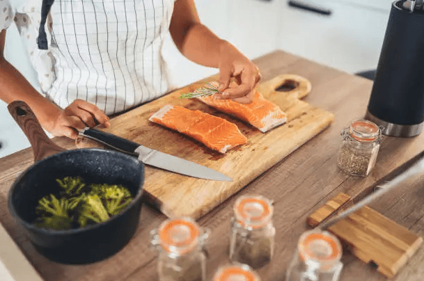 Perfectly cooked salmon fillet straight from frozen, served with a side of fresh vegetables on a white plate.