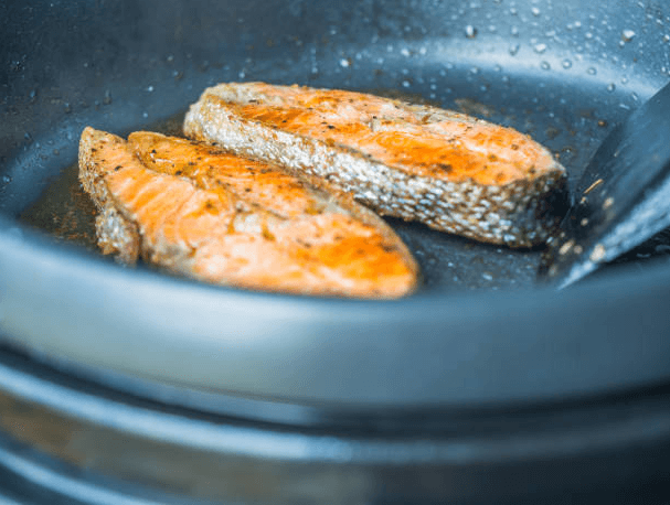 Perfectly cooked salmon fillet in an air fryer basket, showcasing a crispy, golden crust with tender, flaky texture.