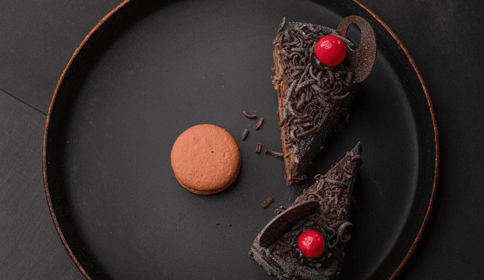 Close-up of a decadent chocolate and cherry dessert featuring rich chocolate layers and fresh cherries, elegantly garnished for a perfect treat.