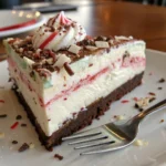 A slice of peppermint ice cream cake with crushed candy canes.